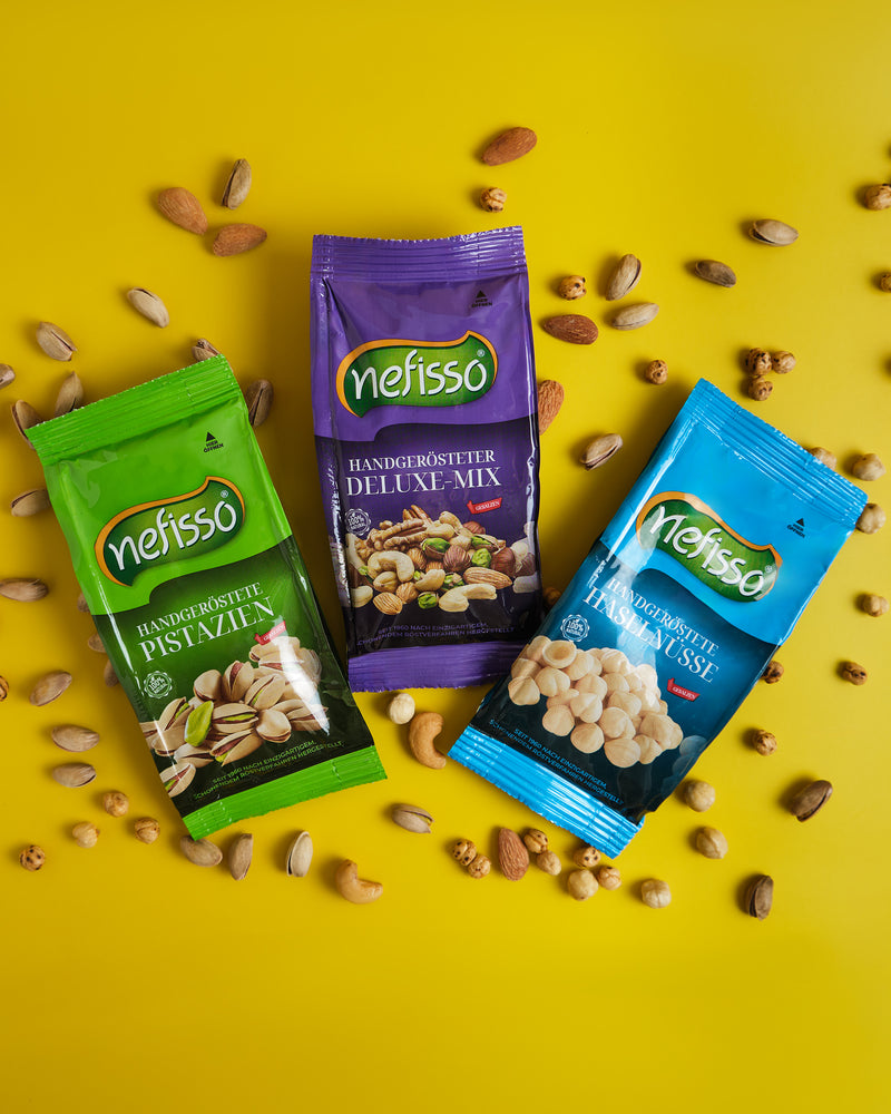 Grüne, violette und blaue Nefisso Packungen mit Pistazien, Deluxe-Mix und Haselnüssen